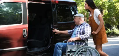 Joyous young man helping elderly patient
