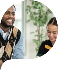 Smiling teacher watching student arranging wood toy in the classroom